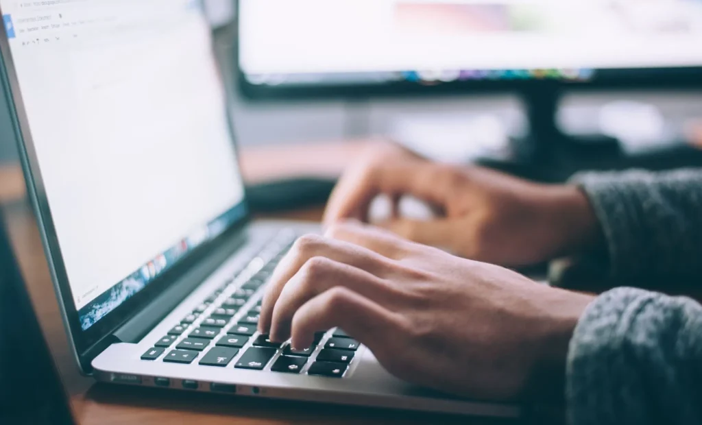 Seseorang sedang mencari informasi share house di laptop.