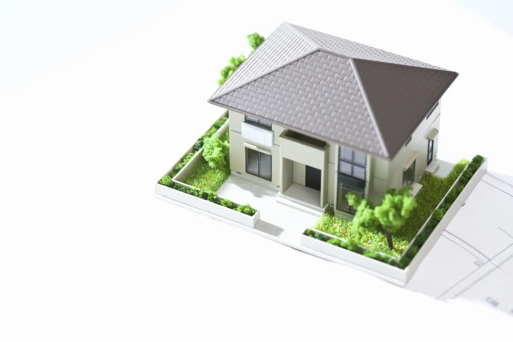 Seseorang memegang kunci rumah di depan sebuah rumah bergaya Jepang.