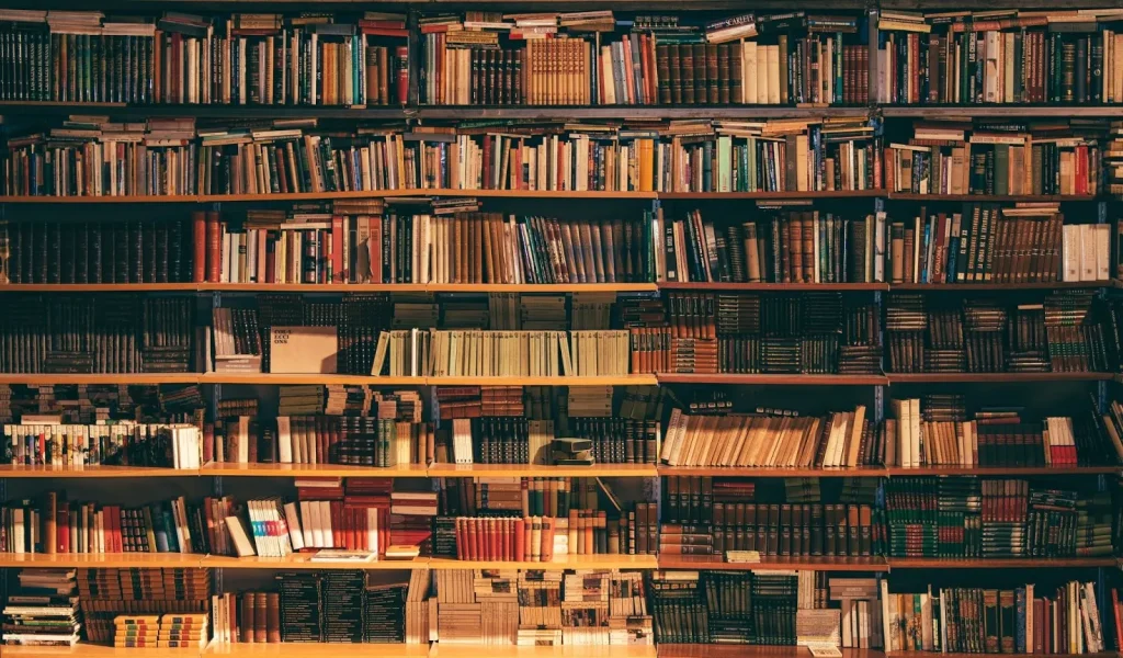 Interior sebuah perpustakaan modern dengan rak-rak buku yang tinggi.