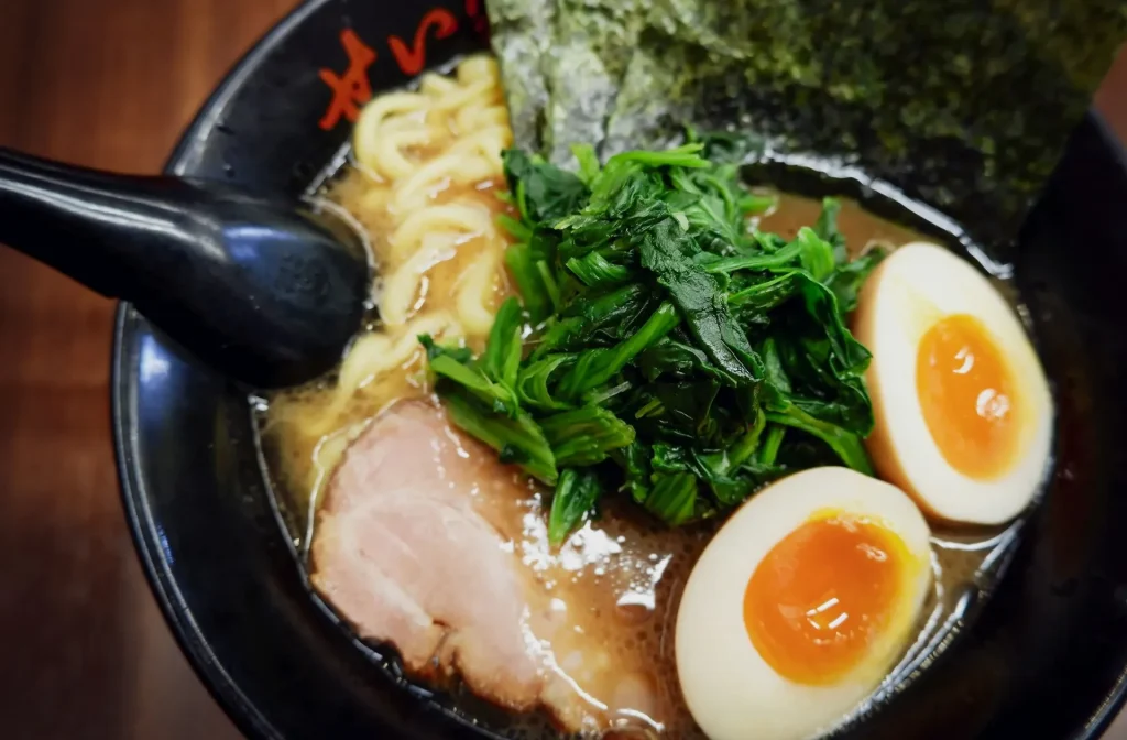 Jajanan takoyaki yang sedang dibuat di atas wajan cetakan khusus.