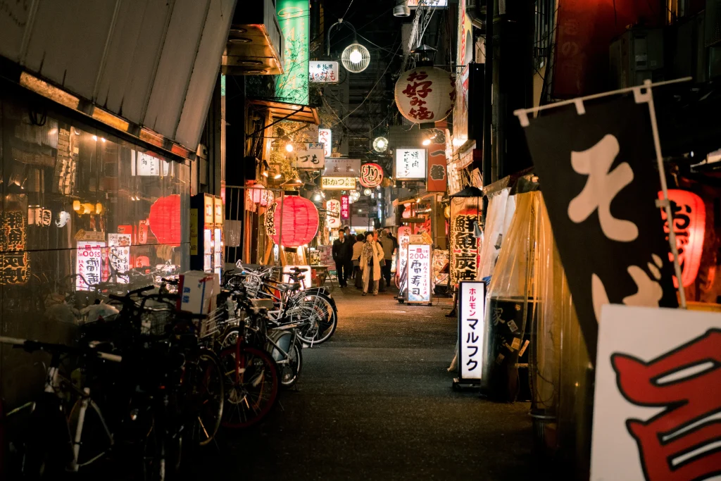 Suasana interior izakaya modern dengan pencahayaan temaram.