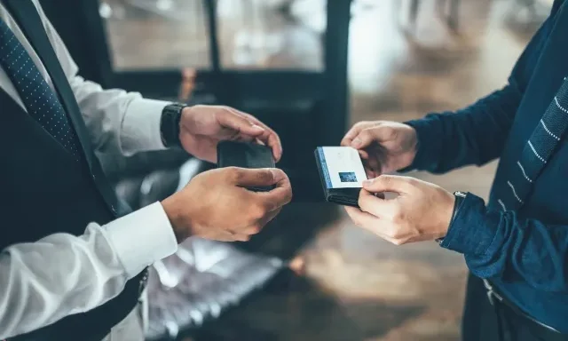 Dua orang pebisnis sedang bertukar kartu nama.